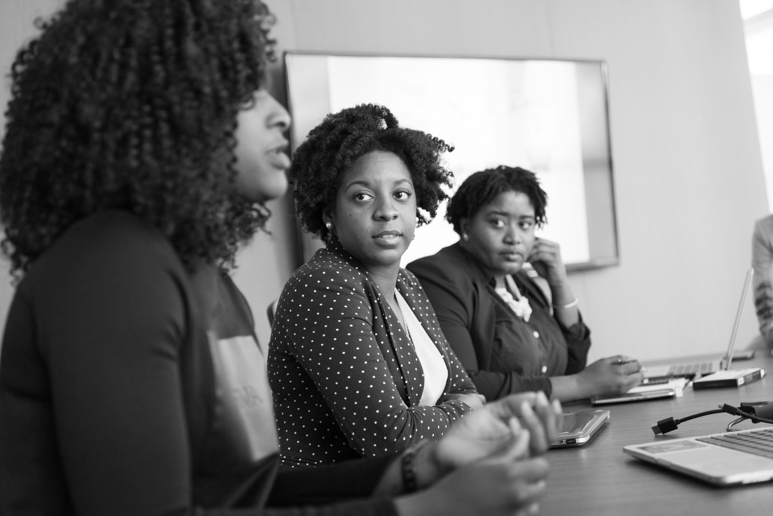 Three women in a meeting, in black and white