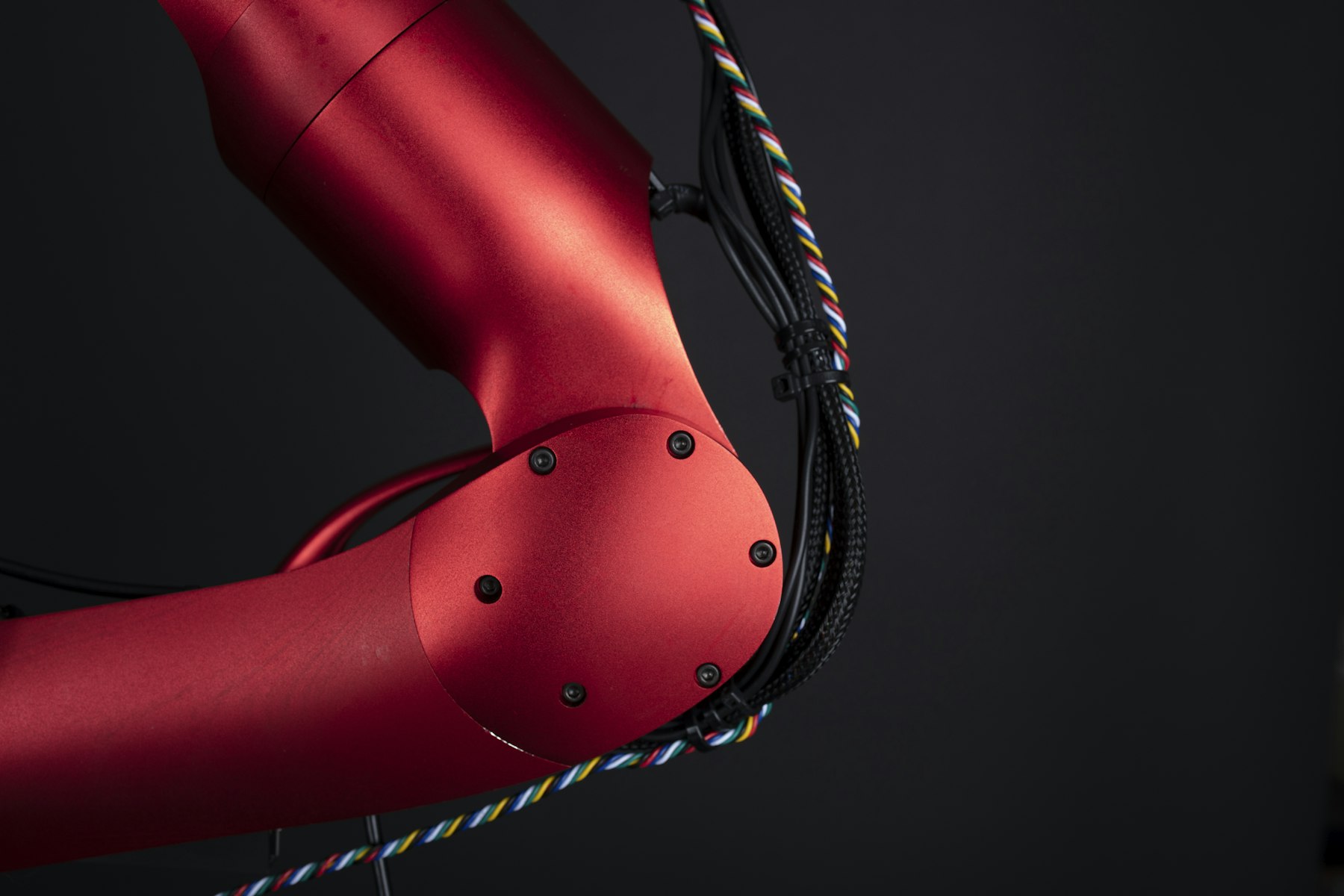 Red robotic arm against a dark background