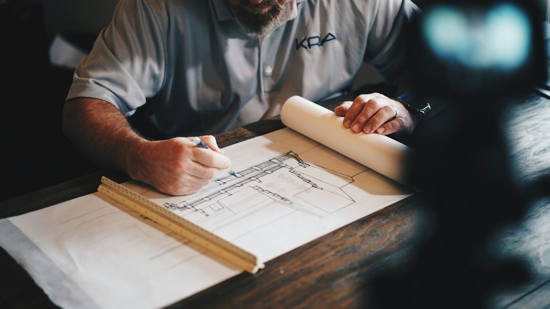 Hands sketching a plan at a drafting table